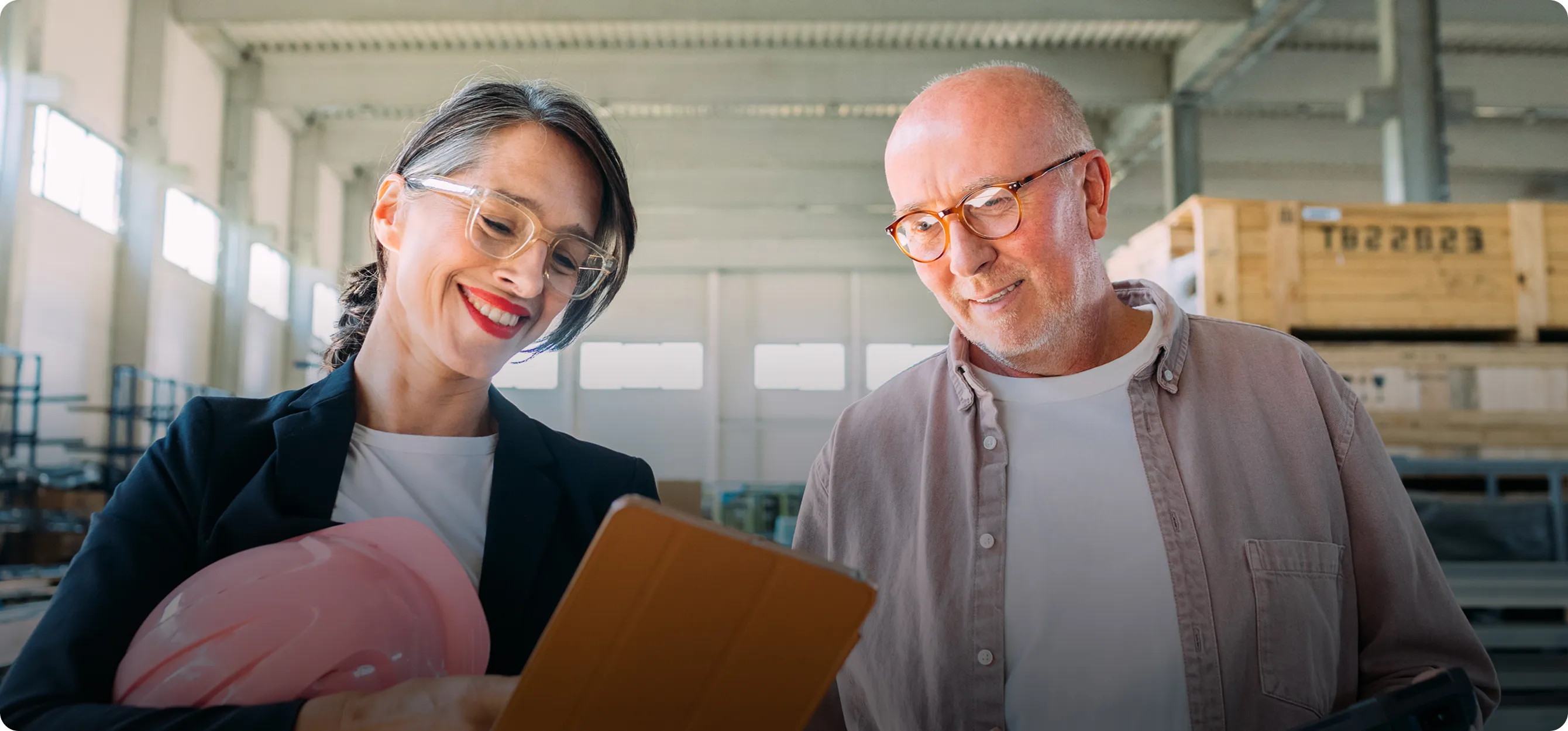 Two business owners reviewing paperwork together at a laptop